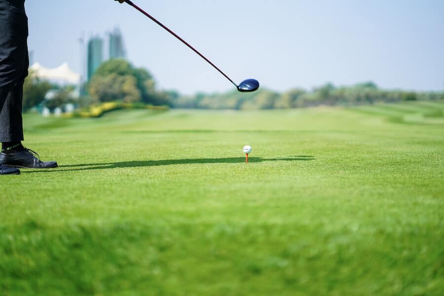 golf player preparing to hit golf ball with driver